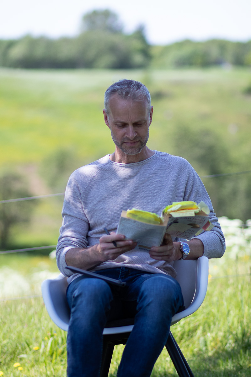 Mand sidder og læser notater udendørs