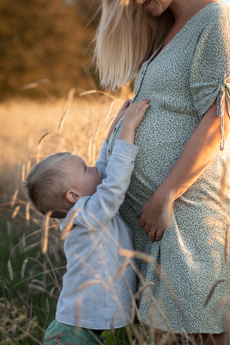 Lille dreng holder om mors mave