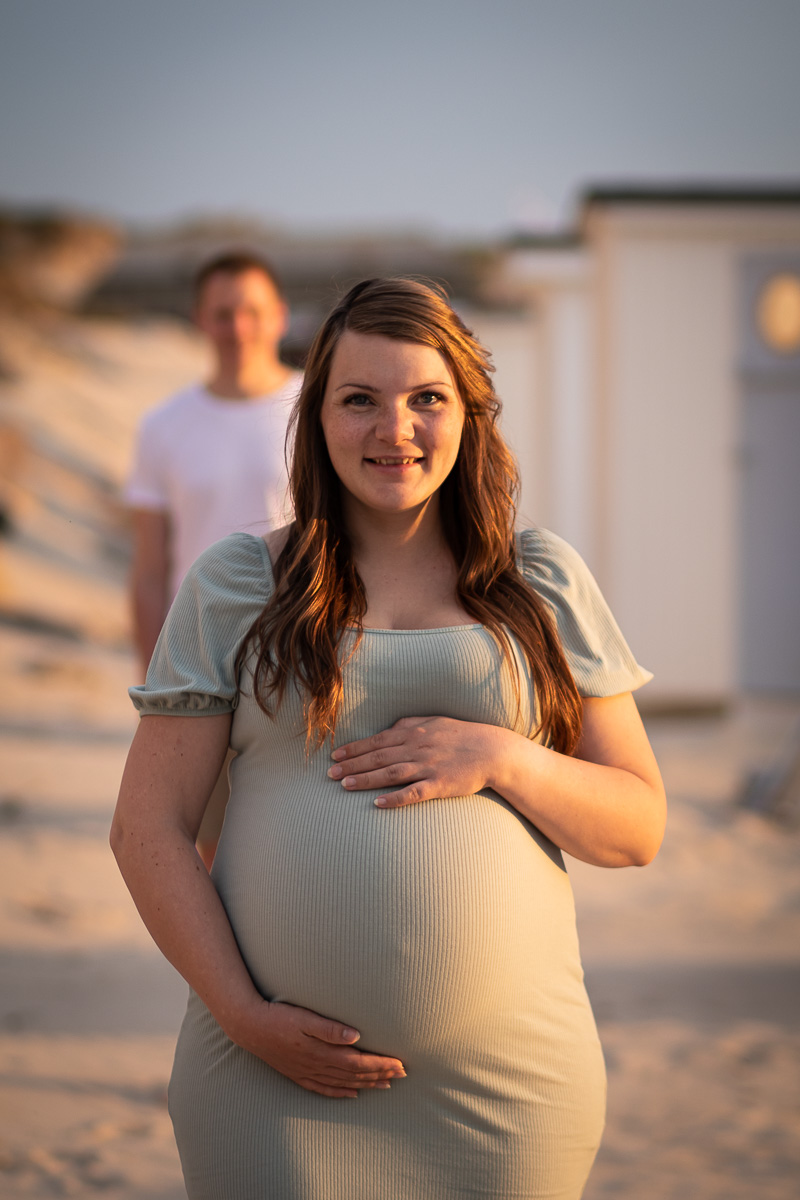 Gravid kvinde kigger på fotografen